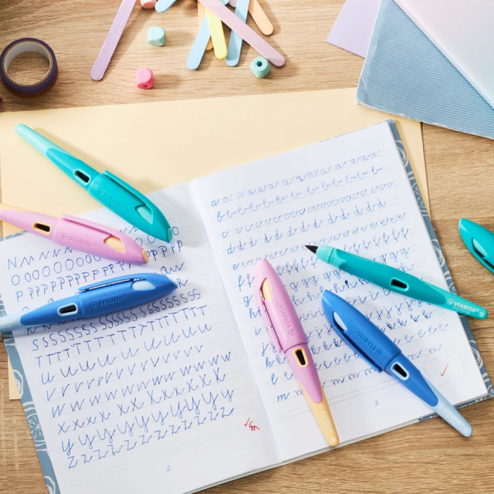 STABILO ergonomischer Schulfüller EASYbirdy pastell aqua grün/mint alle Farben liegen auf einem Heft