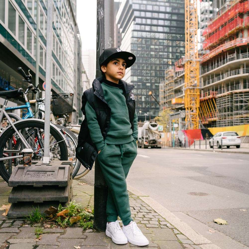 Children Urban Basic Jogginghose - Bottle Green Kind an Straßenlaterne