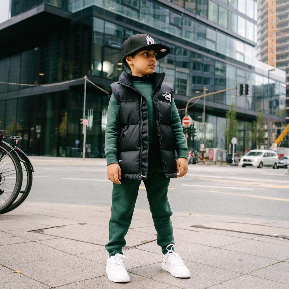 Children Urban Basic Jogginghose - Bottle Green Kind steht an der Straße